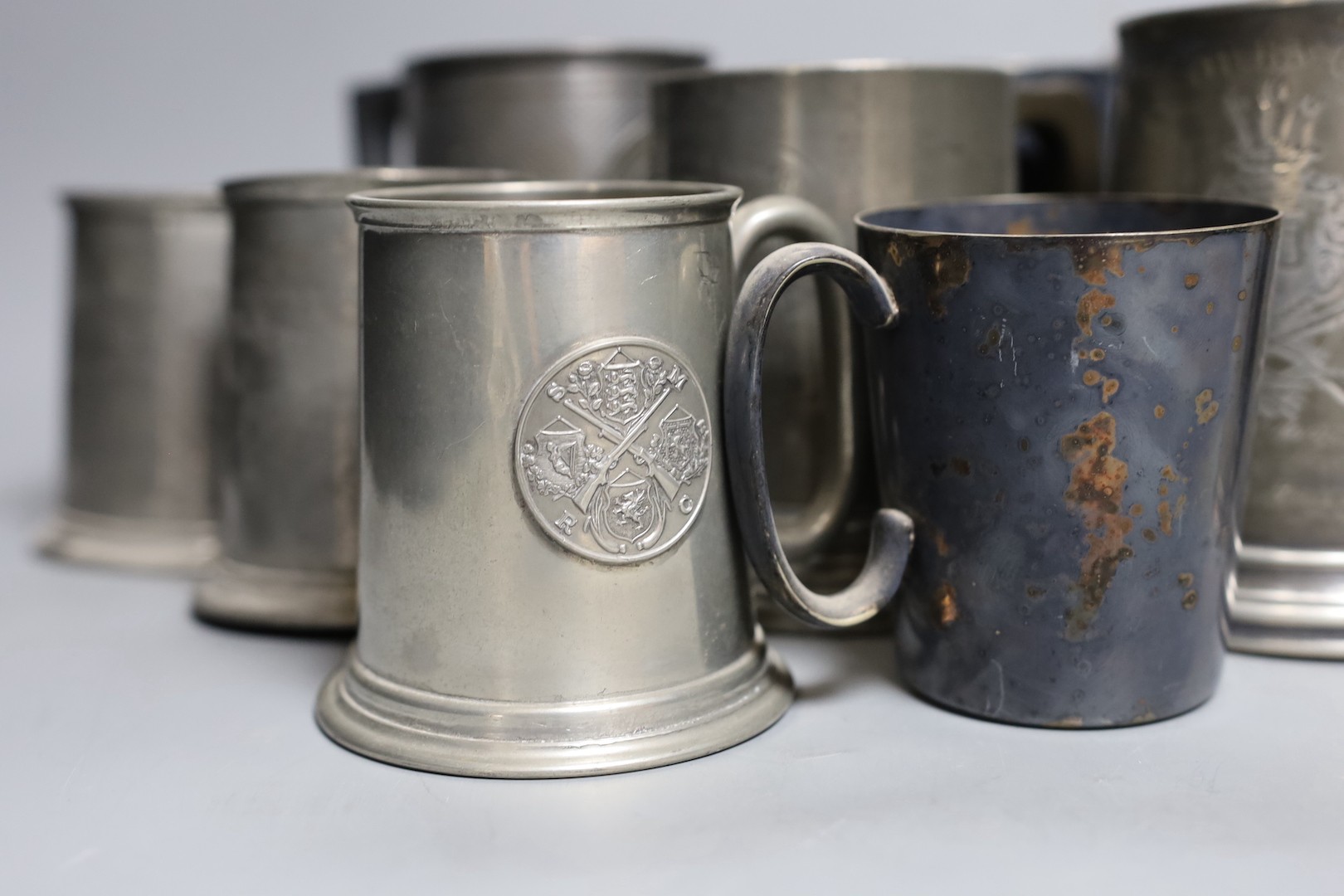 An Edwardian silver Kings company 204th prize Bisley 1904 commemorative beaker, 10cm and a collection of various pewter and plated shooting trophy mugs and tankards, Silver beaker 10 cms high.